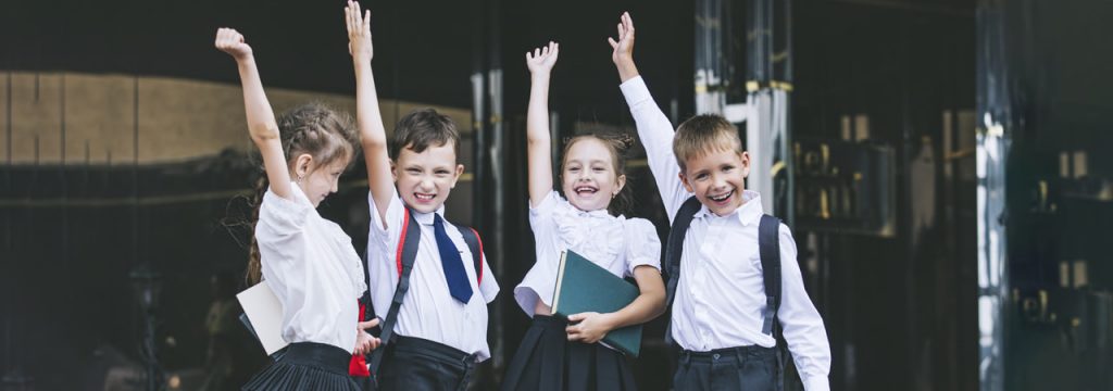 4 kids with their hands up, celebrating