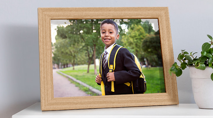 A framed photo of a boy in school uniform on his first day of school