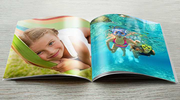 An open softcover photobook with some holiday photos inside