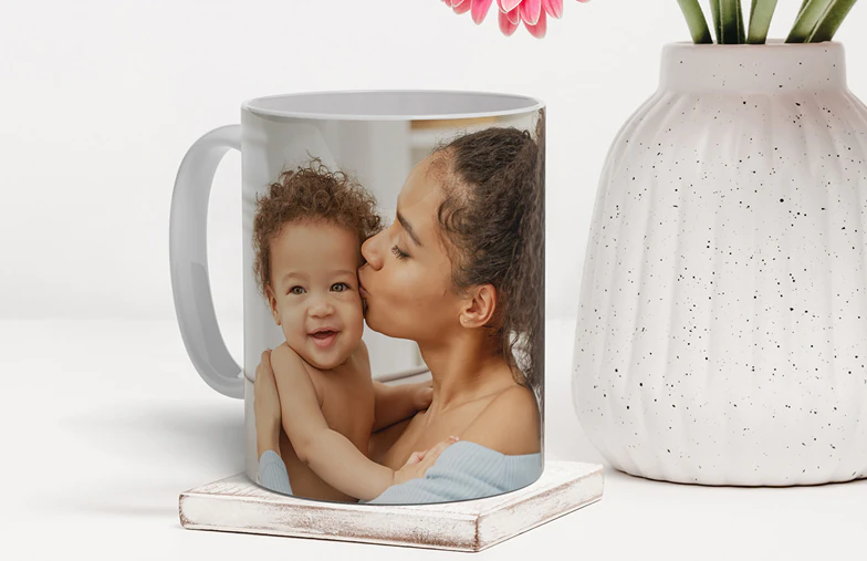 Mum and daughter holding custom designed photo mugs with family photos