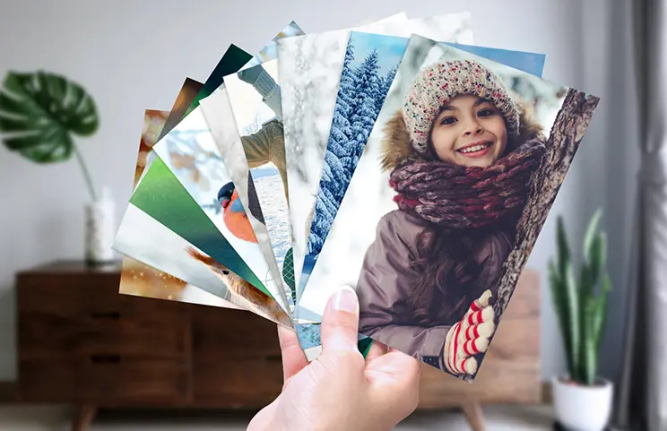 Photo Printing by Printerpix|Stack of custom photo prints from the Printerpix online photo printing service|Small medium and large photo prints on table from mobile phone|Photo Prints|Hands holding a photo print of three kids on holiday|Range of sizes of online photo prints of photos taken by mobile phone of family|||||