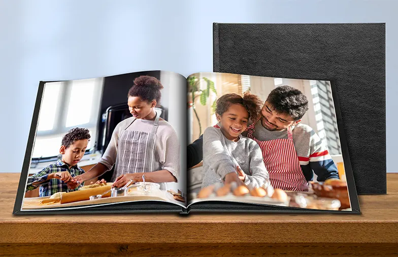 Custom made photo album open on table with photo collage of family photos