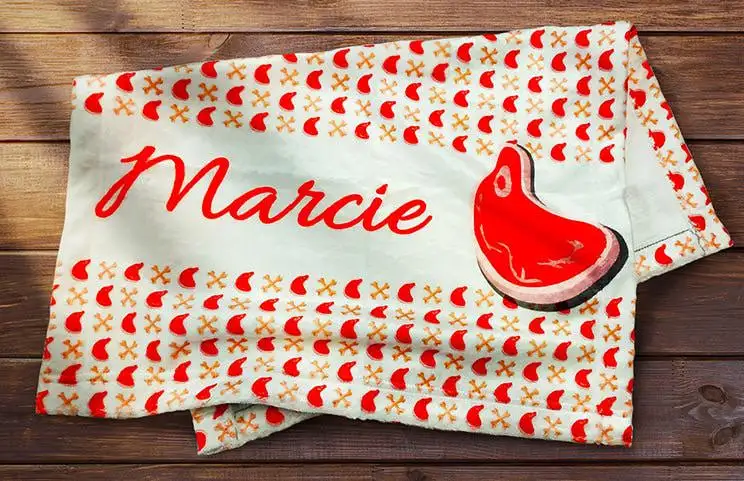 Folded personalised dog blanket with dog name on and picture of dog food