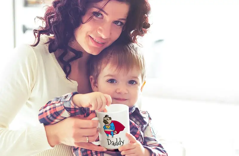 Mom and baby holding Printerpix cartoon design custom mug with dad text
