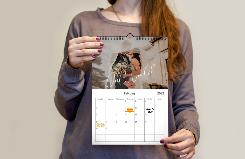 Romantic couple in living room with personalised 2020 wall calendar with proposal photo