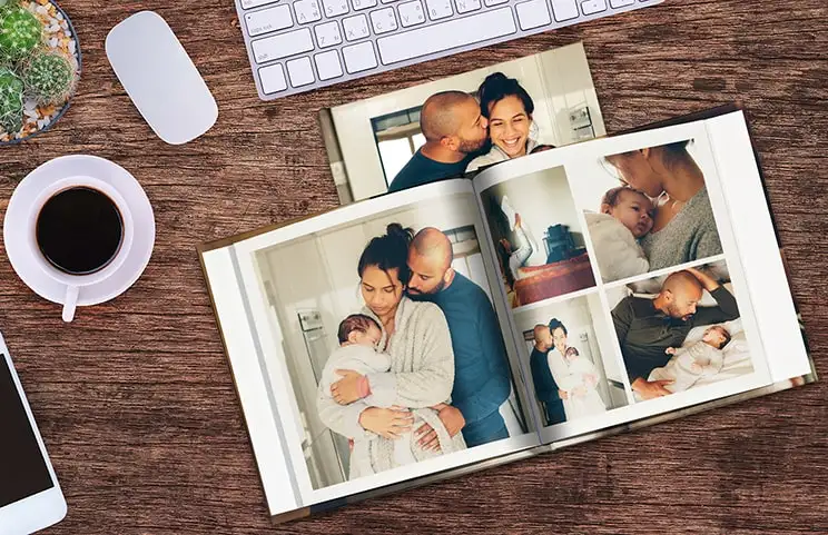 Two people looking at Printerpix custom photo book with wedding photos and bride