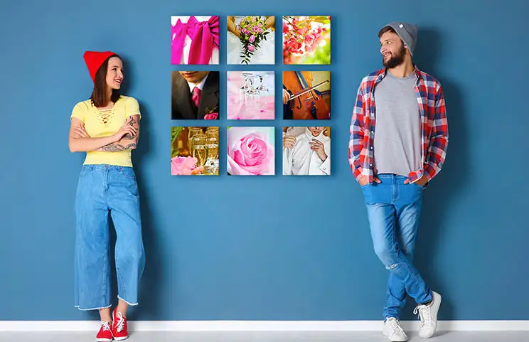 Couple in front of blue wall with nine square photo canvases on